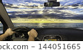 Driving towards a spectacular Mediterranean sunset viewed through the car 144051665